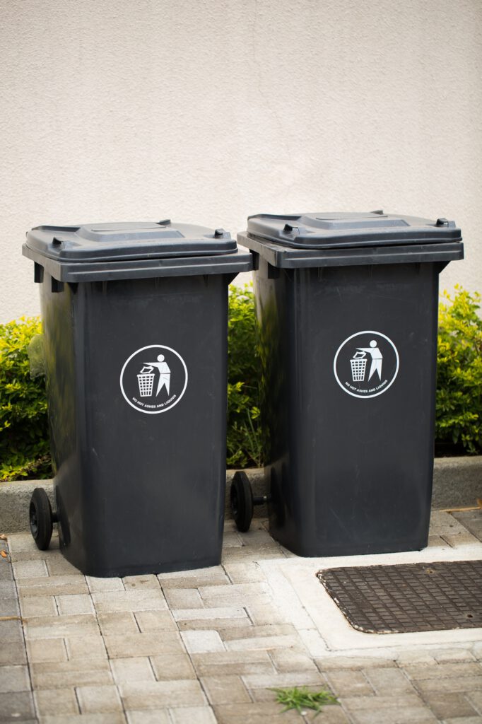 Gebäudereinigung im Bergischen Land Black indoor waste containers for recycling and garbage.